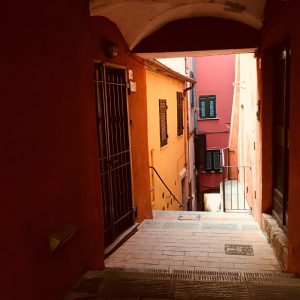 Volto con accesso a Via Roma, Lerici in stile ligure con facciate dalle tonalità calde, stretto carrugio e pavimentazione in mattoni rossi.