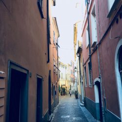 Via Rossi, Sarzana nel punto più stretto tra i palazzi color rosa e ocra con sanpietrini. Location Scout duzimage