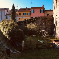 Torrione Sarzana in mattoni. Architettura storica fronte giardini e zona pedonale. Sampietrini. Location Scout duzimage