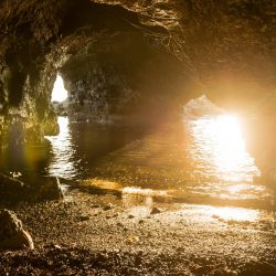 Grotta nei pressi di Fiascherino ed Eco del Mare fotografata da una piccola spiaggia dentro alla grotta con acqua limpida e scogli illuminati dalla luce del tramonto - Locartion Scout Italia - duzimage