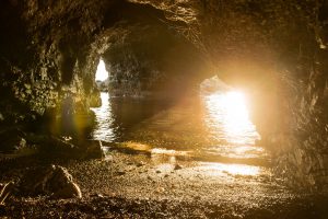 Grotta nei pressi di Fiascherino ed Eco del Mare fotografata da una piccola spiaggia dentro alla grotta con acqua limpida e scogli illuminati dalla luce del tramonto - Locartion Scout Italia - duzimage