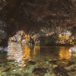 Grotta nei pressi di Fiascherino ed Eco del Mare fotografata da una barca con acqua limpida e scogli illuminati dalla luce del tramonto - Locartion Scout Italia - duzimage