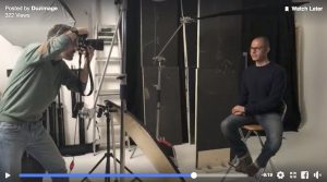 frame del video Live Facebook nello studio duzimage. David Umberto Zappa ritrae Paolo Corradeghini seduto circondato da flash e modellatori fotografici
