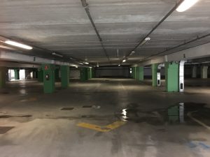 Parcheggio sotterraneo centro commercial Leclerc di Santo Stefano Magra. Umidità sul pavimento in cemento, segnaletica orizzontale, condotti dell'aria - Location Scout duzimage https://www.duzimage.com/category/locationscouting/