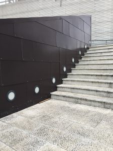 Area pedonale di fronte all'ingresso del centro commerciale Leclerc di Santo Stefano Magra. Muro in metallo, pavimentazione lastricata e cemento. Location Scout duzimage https://www.duzimage.com/category/locationscouting/