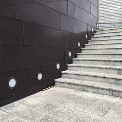 Area pedonale di fronte all'ingresso del centro commerciale Leclerc di Santo Stefano Magra. Muro in metallo, pavimentazione lastricata e cemento. Location Scout duzimage https://www.duzimage.com/category/locationscouting/