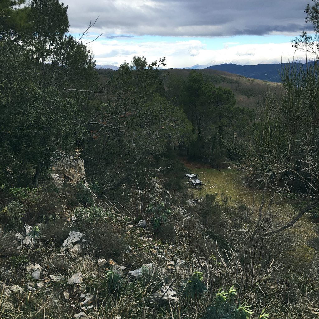 auto abbandonata nei pressi della Rocchetta di Lerici. Fitta vegetazione ligure con nuvole sullo sfondo in direzione Nord