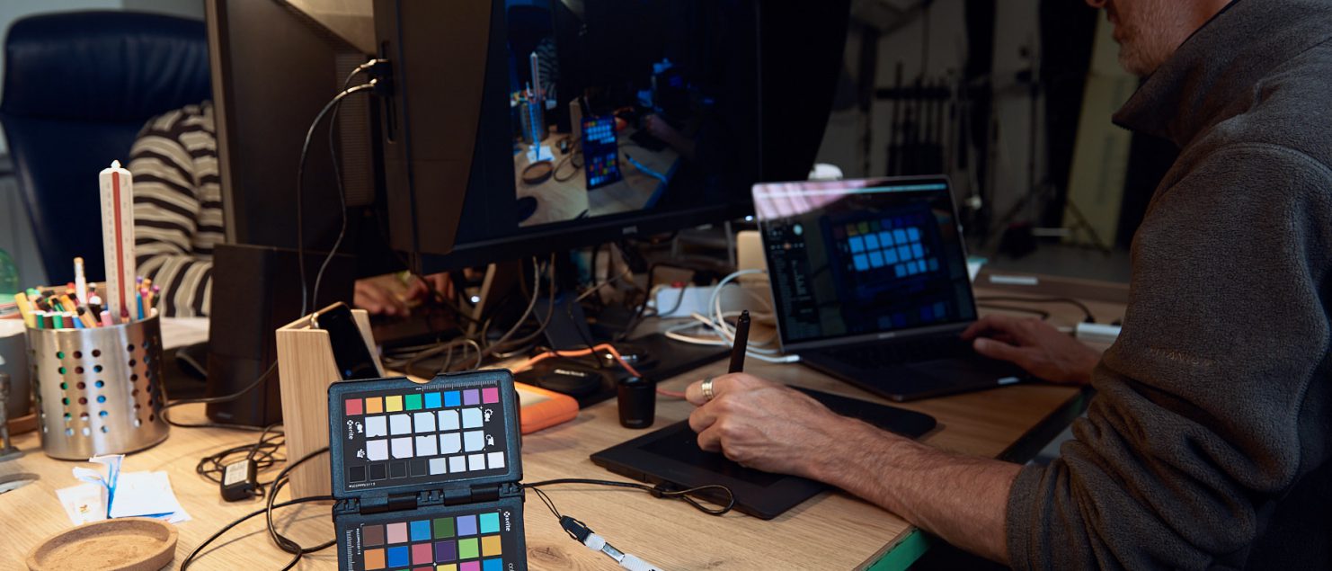 Color Checker X-rite sulla scrivania dello studio duzimage con monitor BenQ e Mac Book Pro sullo sfondo.
