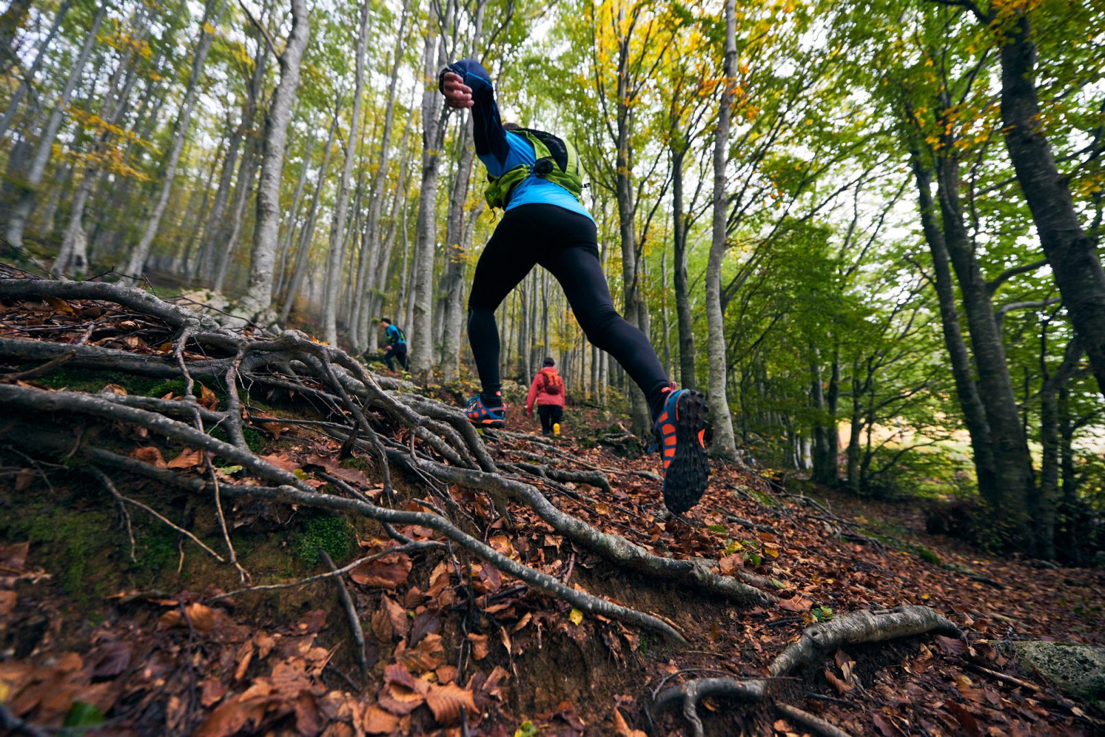 Man trail running with foot in foreground. Uomo che fa trail running con piede in primo piano