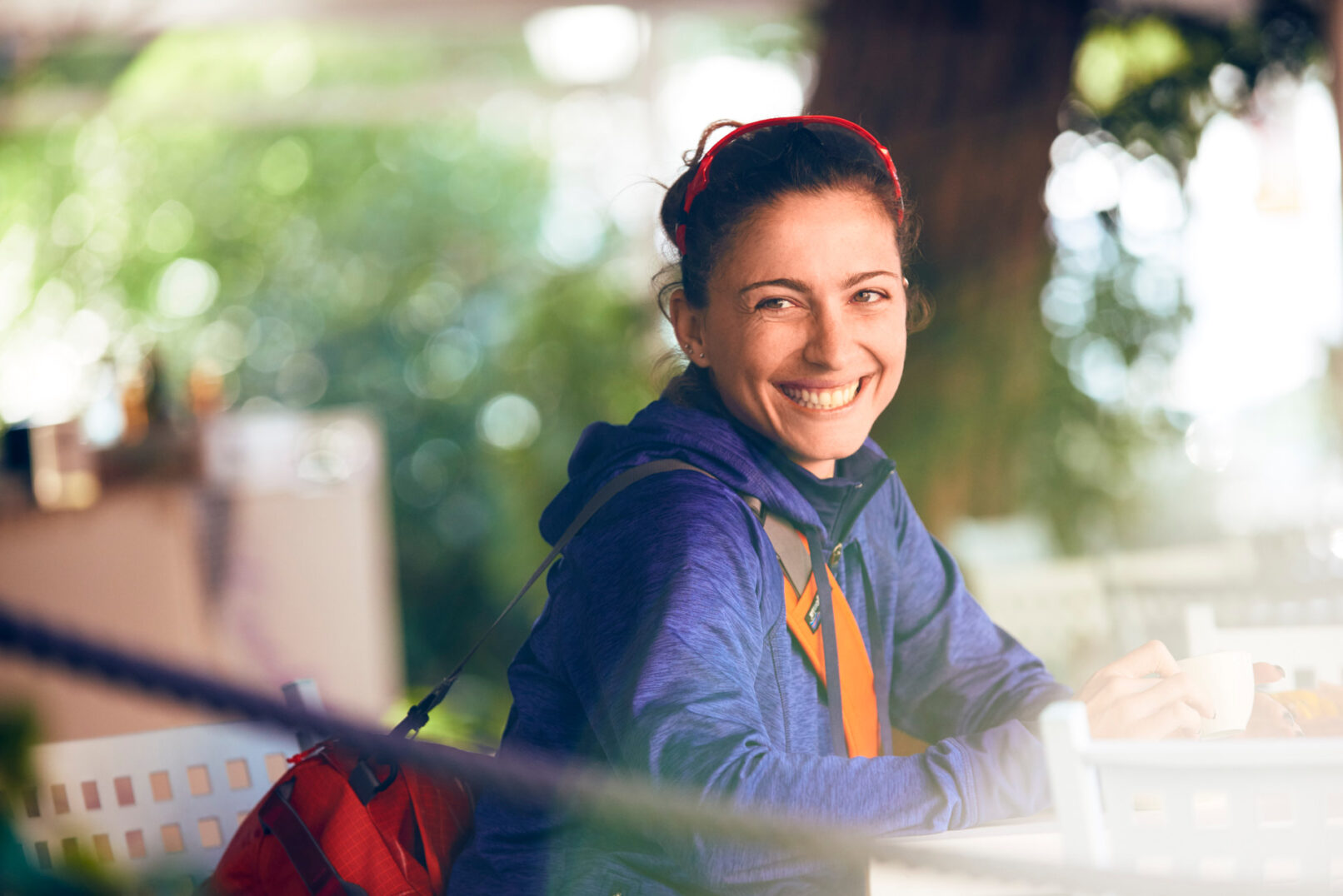 Fotografia ritratto di ragazza che sorride. indossa abbigliamento sportivo, borsa, occhiali da sole. fotografo sportivo duzimage di David Umberto Zappa, fotografo La Spezia