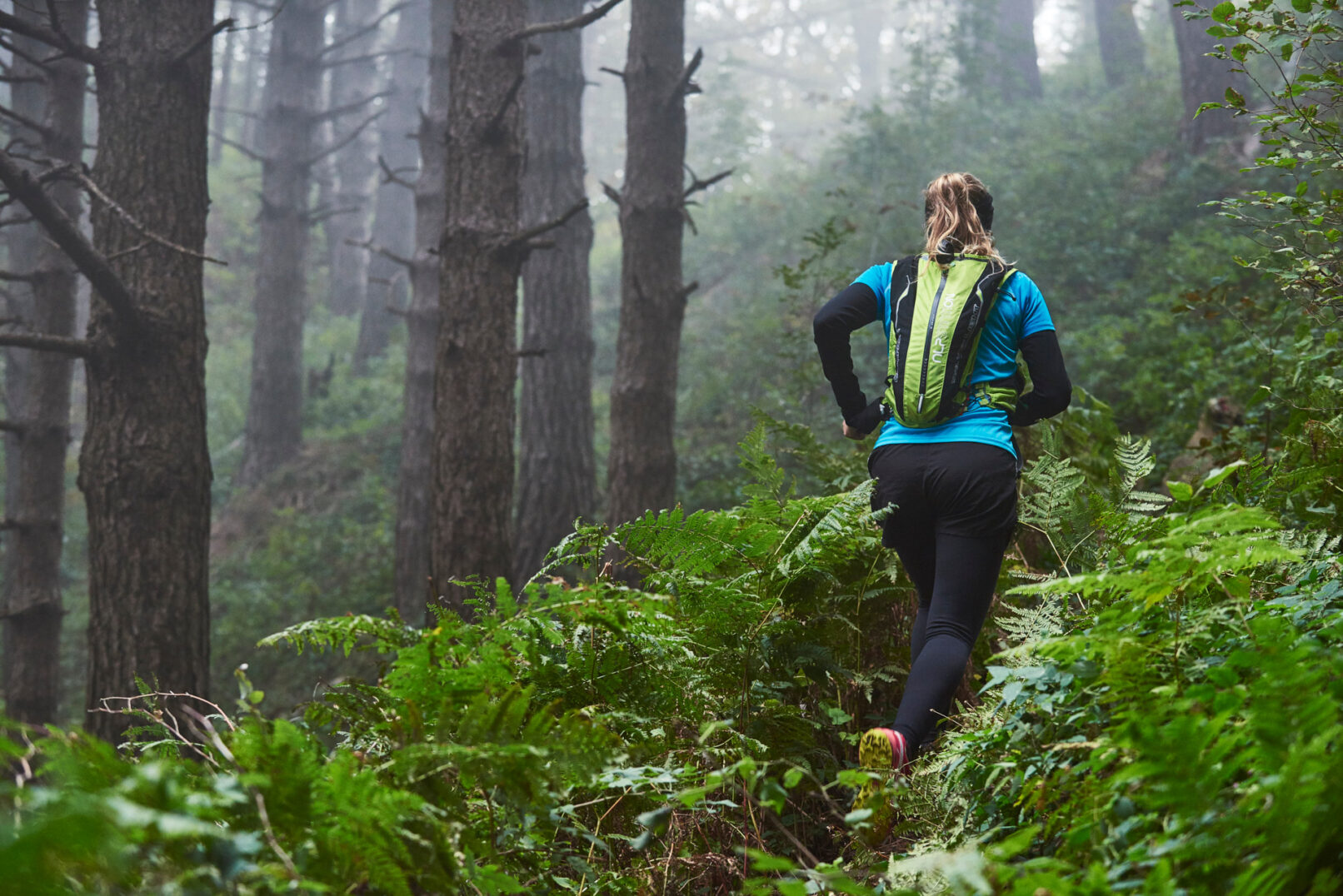 Fotografia di ragazza che pratica trailrunning nel bosco. Scatto realizzato per Polygiene dal fotografo sportivo