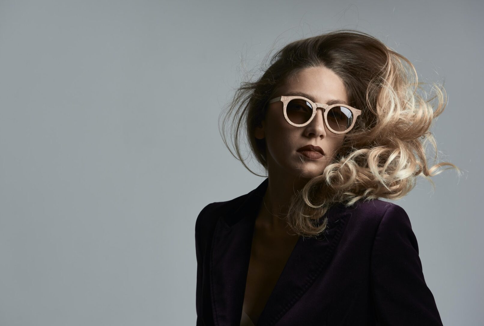 Ritratto di ragazza con occhiali da sole, capelli mossi dal vento, biondi realizzato nello studio del fotografo duzimage - David Umberto Zappa in provincia di La Spezia